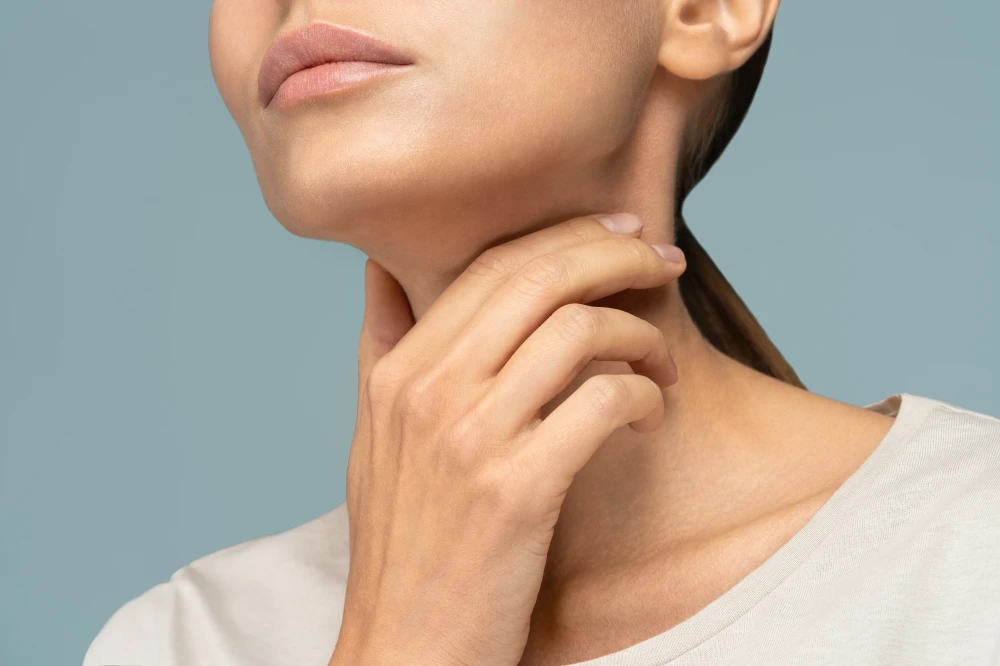 אישה מחזיקה את הגרון כי סובלת מכאב