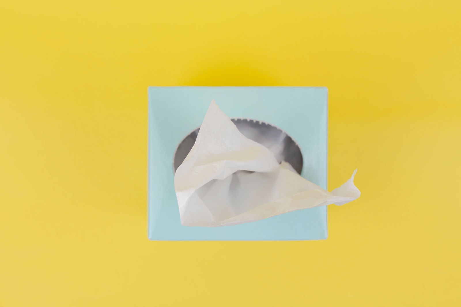 white paper boat on yellow surface